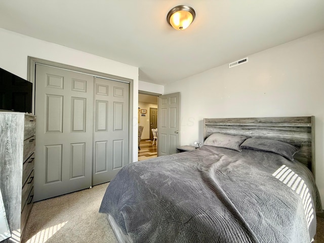bedroom with visible vents, a closet, and carpet