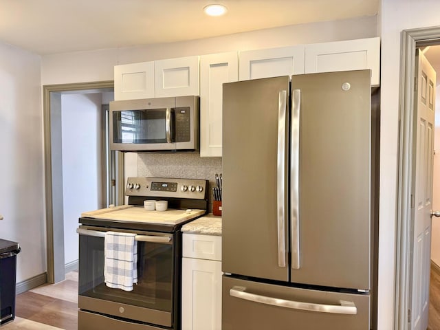 kitchen featuring appliances with stainless steel finishes, white cabinetry, recessed lighting, and light wood-style floors