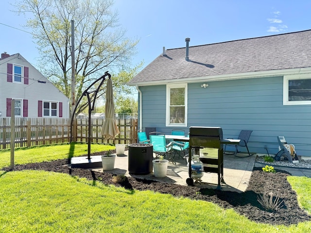 back of house with a patio, fence, a yard, and roof with shingles