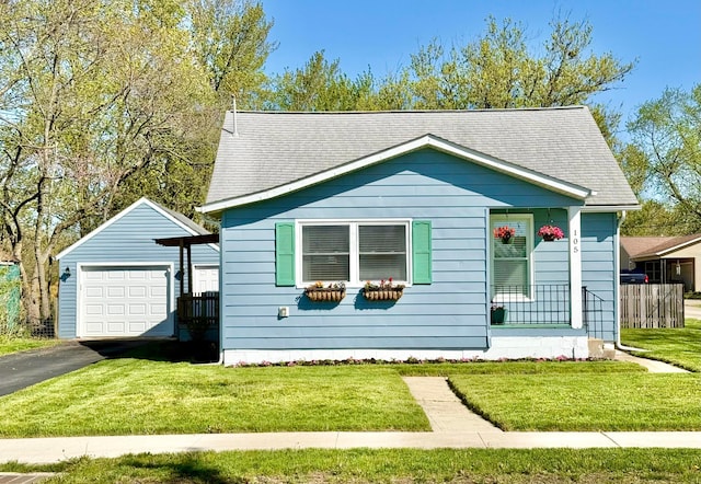 view of front of property featuring a shingled roof, an outdoor structure, a front lawn, and driveway