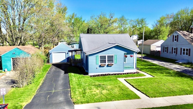 bungalow-style home with a garage, an outdoor structure, and a front yard