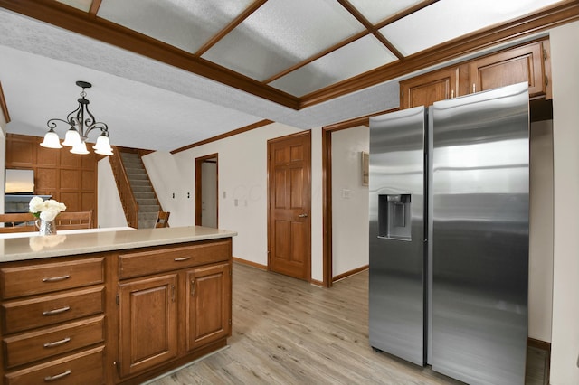 kitchen with pendant lighting, a chandelier, brown cabinets, stainless steel fridge with ice dispenser, and light wood-style flooring
