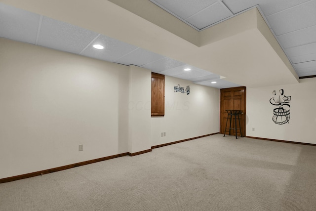 finished below grade area with baseboards, carpet, recessed lighting, and a paneled ceiling