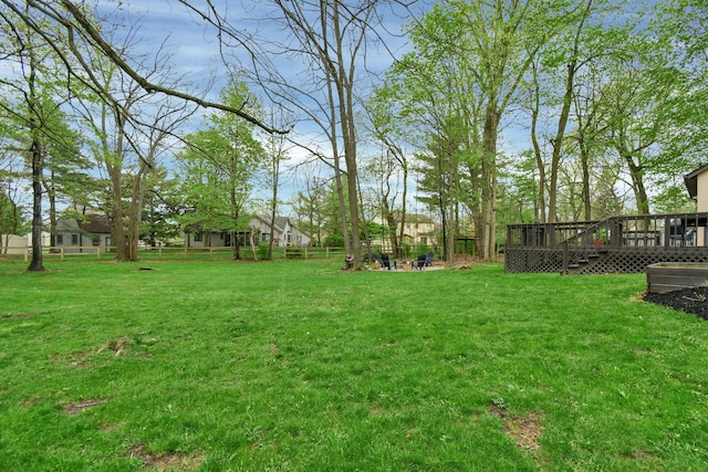 view of yard featuring a wooden deck and fence