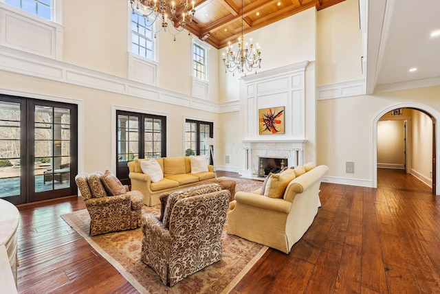 living room featuring arched walkways, a chandelier, recessed lighting, and dark wood-type flooring