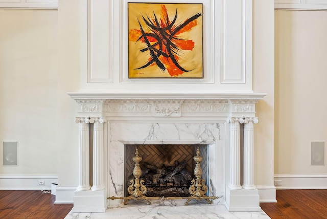 interior details featuring a premium fireplace, baseboards, and wood finished floors
