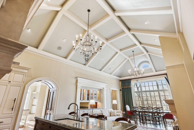 dining room featuring visible vents, arched walkways, high vaulted ceiling, beamed ceiling, and an inviting chandelier