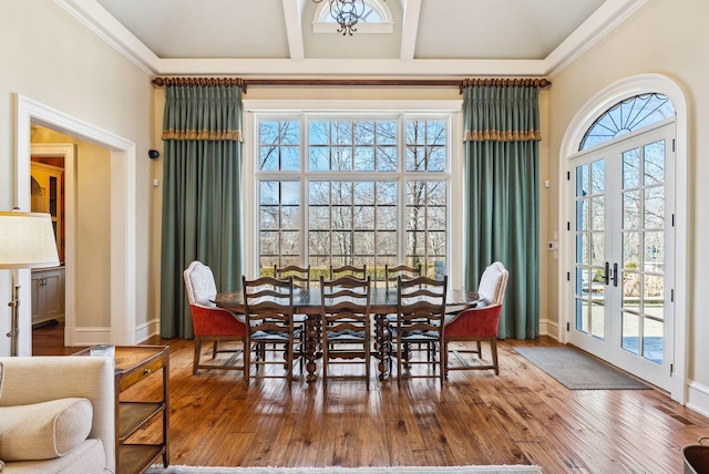 dining room with baseboards, beamed ceiling, french doors, and hardwood / wood-style floors
