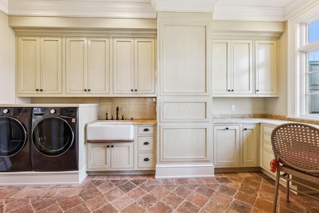 washroom featuring cabinet space, a sink, separate washer and dryer, stone finish flooring, and ornamental molding
