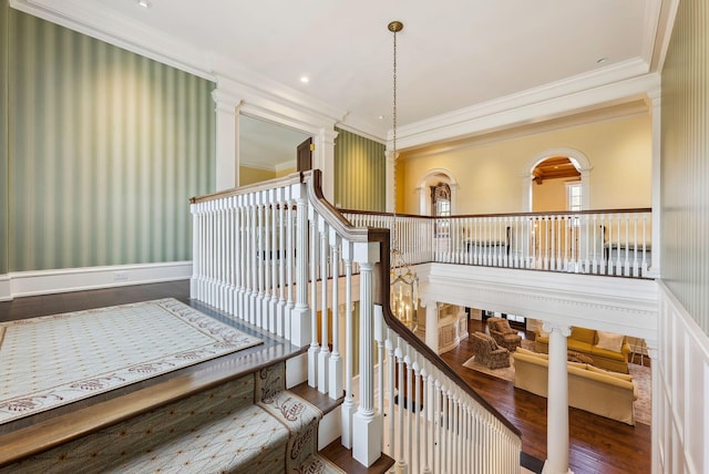 staircase featuring crown molding and wood finished floors