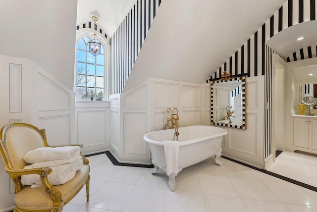 interior space featuring a towering ceiling, wainscoting, and a decorative wall