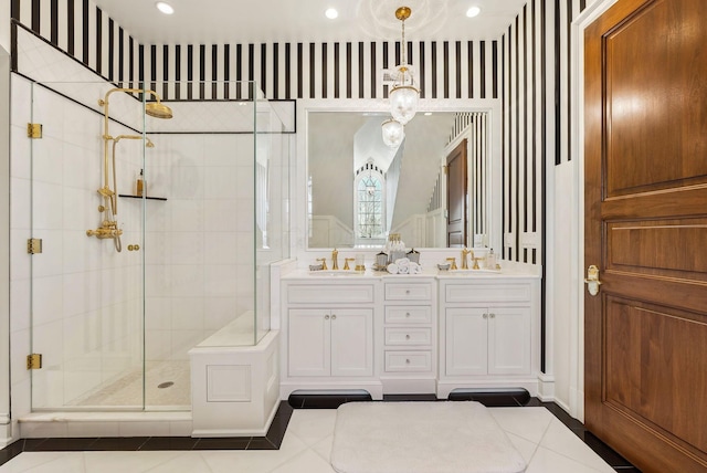full bathroom with double vanity, a shower stall, and a sink