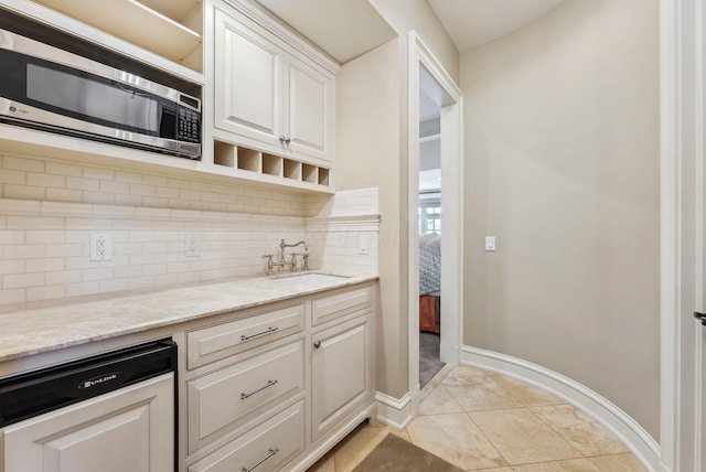 kitchen with backsplash, open shelves, a sink, white cabinets, and stainless steel microwave