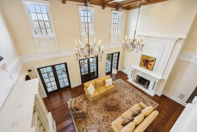 living room featuring an inviting chandelier, plenty of natural light, and french doors