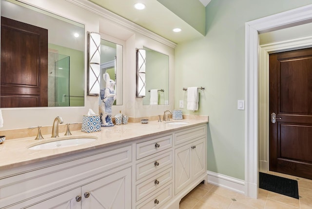 full bath featuring baseboards, double vanity, tile patterned floors, and a sink