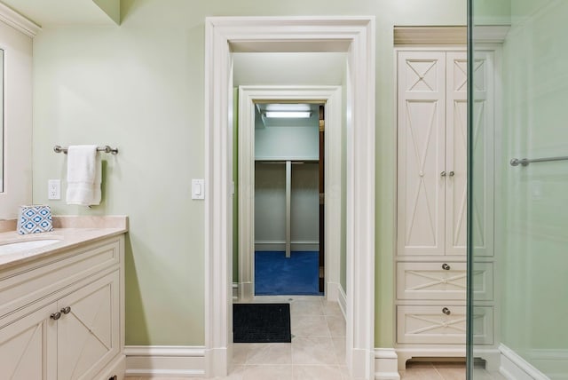 bathroom featuring a closet, baseboards, tile patterned flooring, and vanity