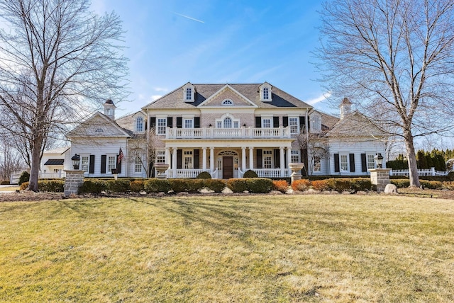 view of front of property with a porch, a front lawn, and a chimney
