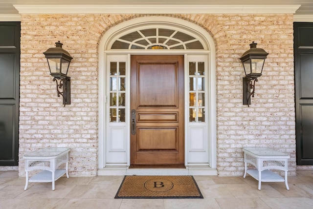 entrance to property with covered porch and brick siding