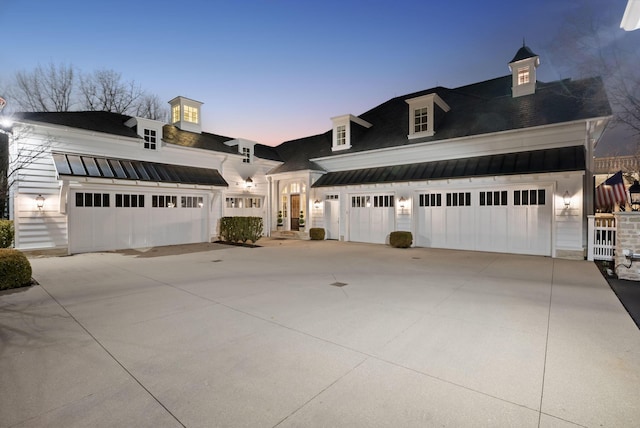 view of front of house featuring concrete driveway, a standing seam roof, and metal roof