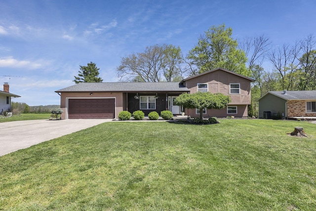 tri-level home featuring an attached garage, a front yard, and concrete driveway