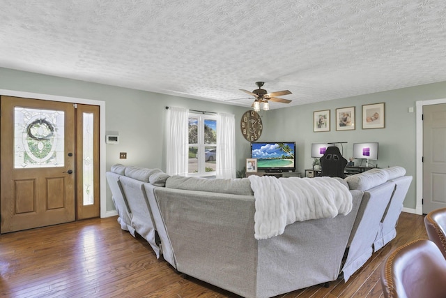 living room featuring wood-type flooring, a textured ceiling, and ceiling fan