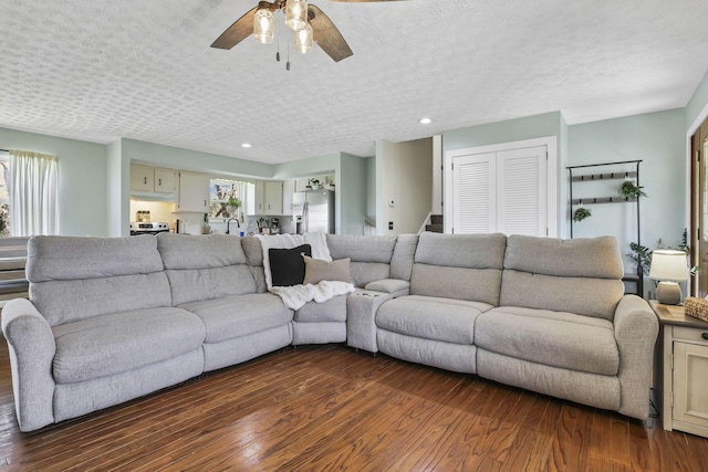 living area featuring a ceiling fan, recessed lighting, and dark wood-type flooring