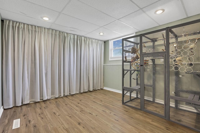 spare room with a paneled ceiling, recessed lighting, baseboards, and wood finished floors