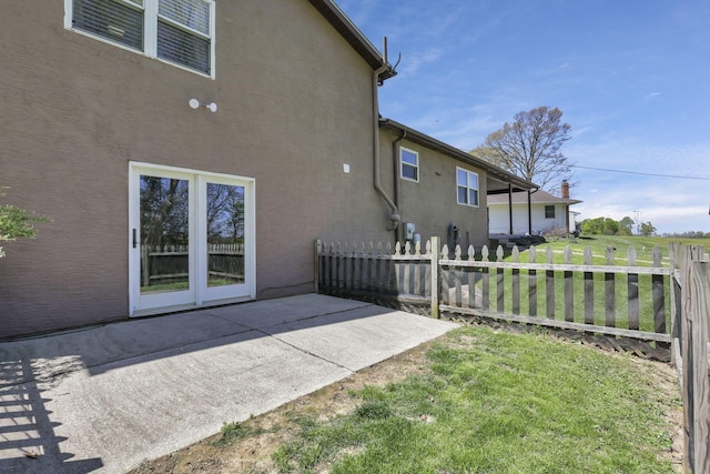 back of property with a patio, stucco siding, a yard, and fence