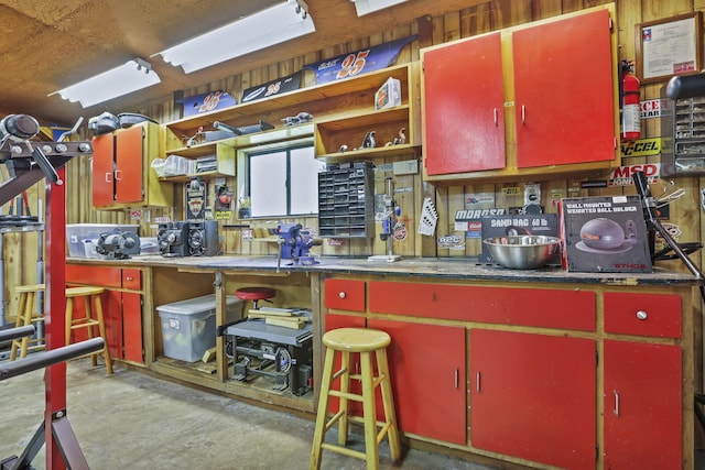 kitchen with red cabinetry, open shelves, unfinished concrete flooring, and yellow cabinets