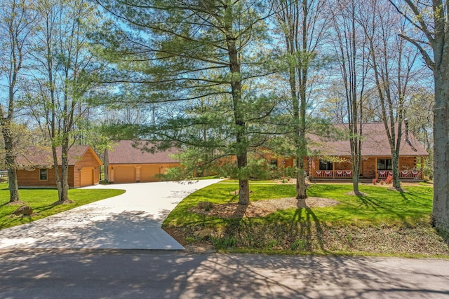 view of front of home featuring covered porch, driveway, and a front lawn