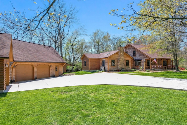 view of front of house with a front lawn, roof with shingles, a chimney, and a detached garage