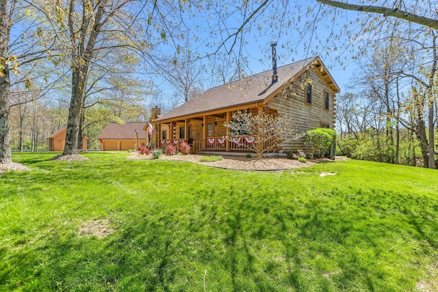 back of house with log exterior, a yard, a porch, and a chimney