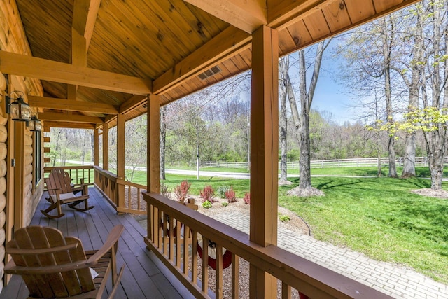 wooden terrace featuring fence and a yard