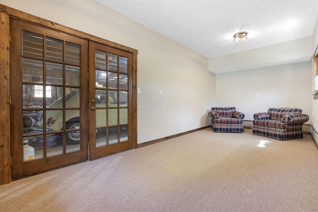 unfurnished room featuring baseboards, carpet, french doors, and a textured ceiling