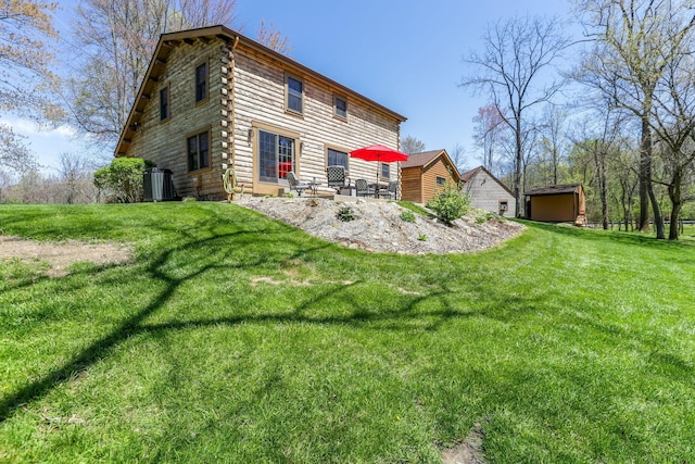 rear view of house with an outdoor structure, a patio area, log exterior, a lawn, and a storage shed