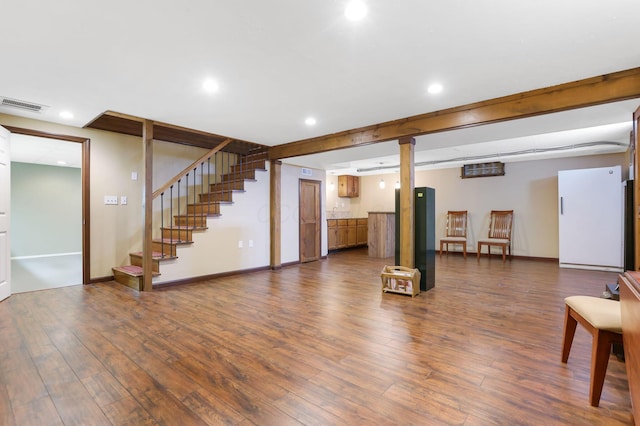 finished below grade area featuring recessed lighting, baseboards, visible vents, and dark wood finished floors