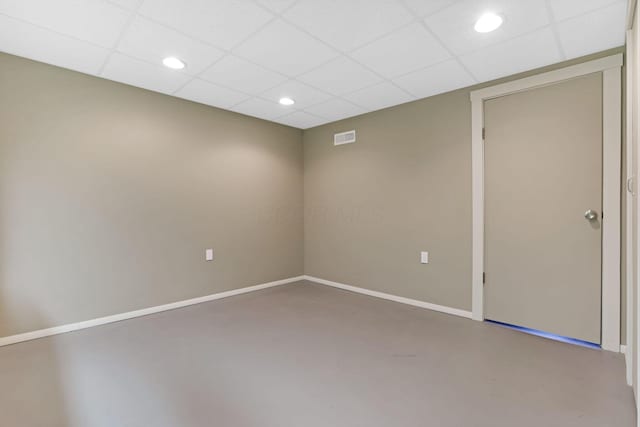 interior space with a paneled ceiling, visible vents, concrete flooring, baseboards, and recessed lighting