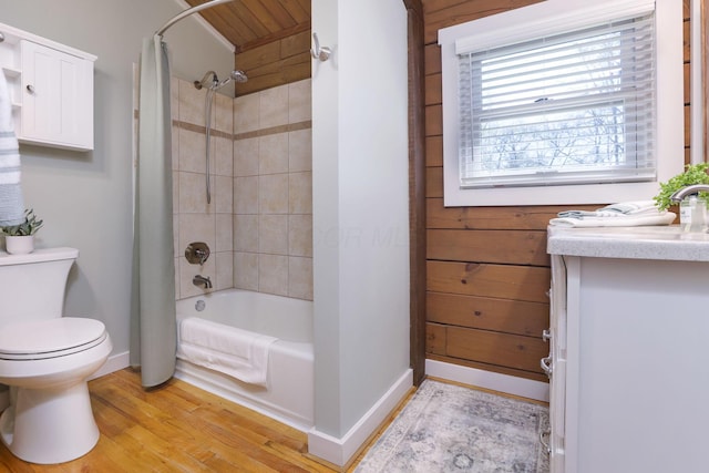 full bathroom with vanity, toilet, shower / bathtub combination with curtain, baseboards, and wood finished floors