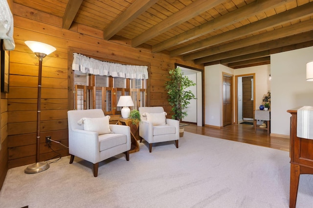 living area with wood ceiling, beam ceiling, and carpet