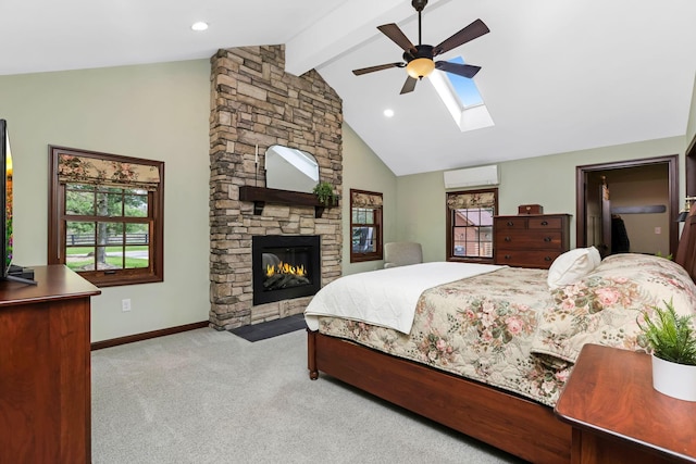 bedroom with carpet flooring, an AC wall unit, multiple windows, and vaulted ceiling with skylight