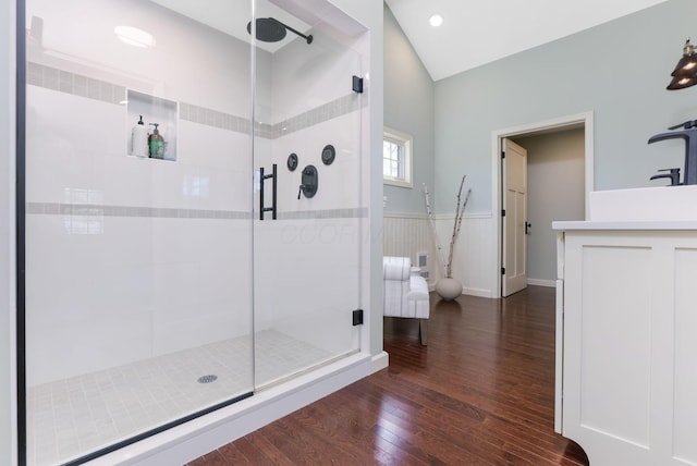 bathroom with vanity, a wainscoted wall, a stall shower, and wood finished floors