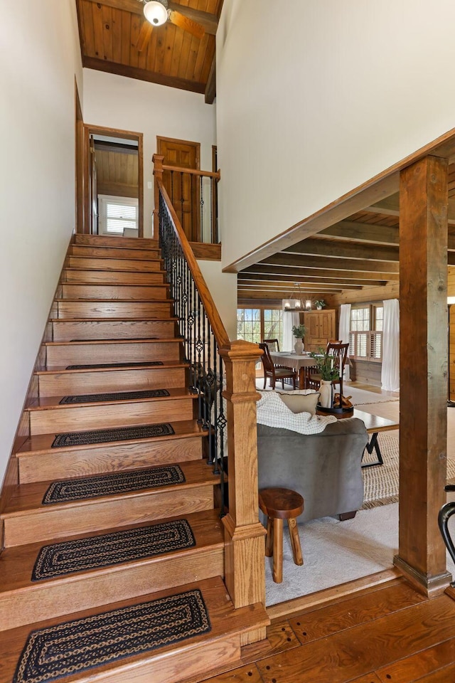 stairs with wooden ceiling, high vaulted ceiling, wood-type flooring, and beam ceiling
