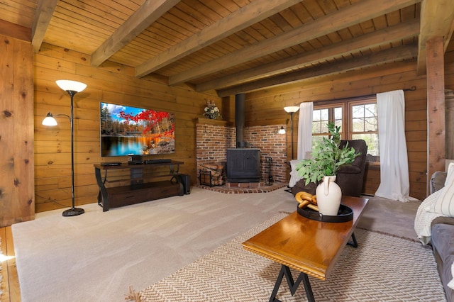 carpeted living area featuring a wood stove, wood ceiling, wooden walls, and beamed ceiling