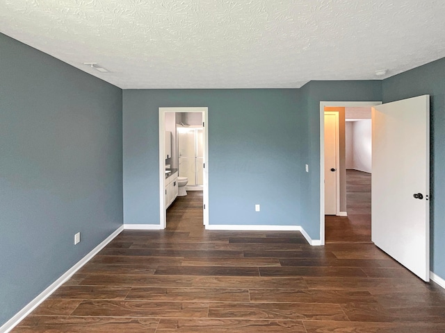 unfurnished bedroom featuring baseboards, a textured ceiling, and wood finished floors