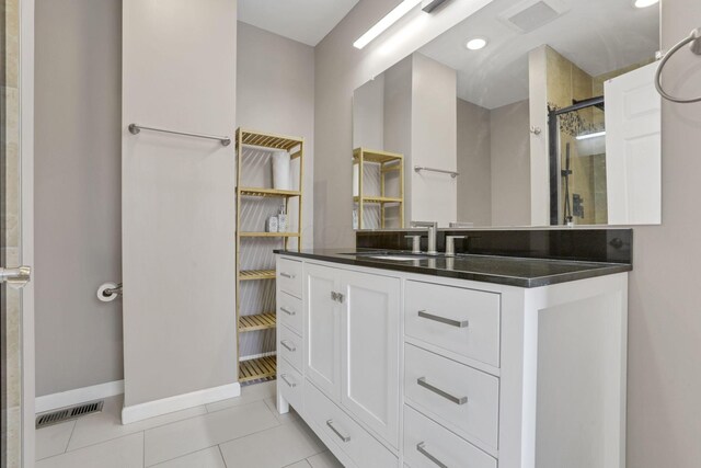360 Hosack St, Columbus, OH 43207 - bathroom with visible vents, tile patterned flooring, a stall shower, vanity, and baseboards