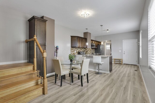 360 Hosack St, Columbus, OH 43207 - dining space with light wood-style floors, stairs, baseboards, and a healthy amount of sunlight