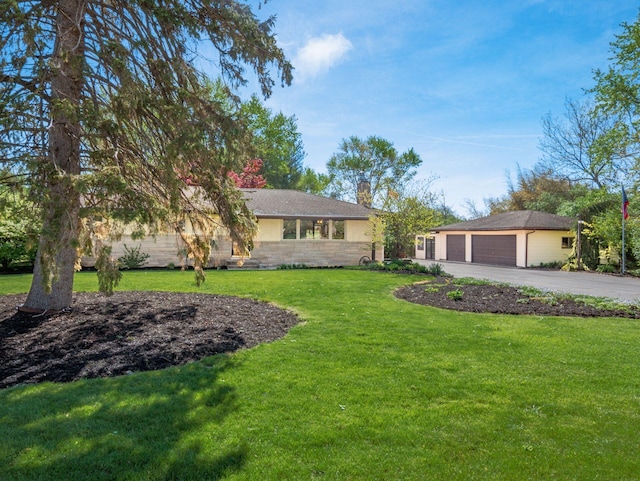 single story home featuring driveway, a chimney, a front yard, an attached garage, and stone siding