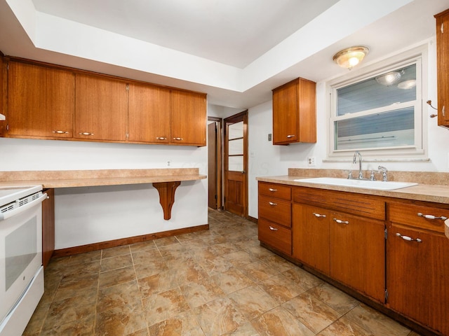 kitchen featuring a sink, light countertops, white range with electric cooktop, and brown cabinetry