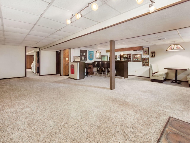 finished below grade area with baseboards and a paneled ceiling
