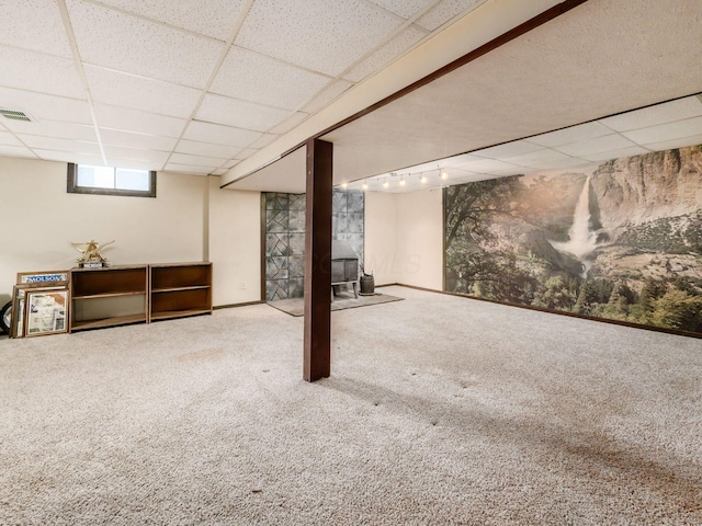 below grade area with visible vents, carpet flooring, a paneled ceiling, and rail lighting